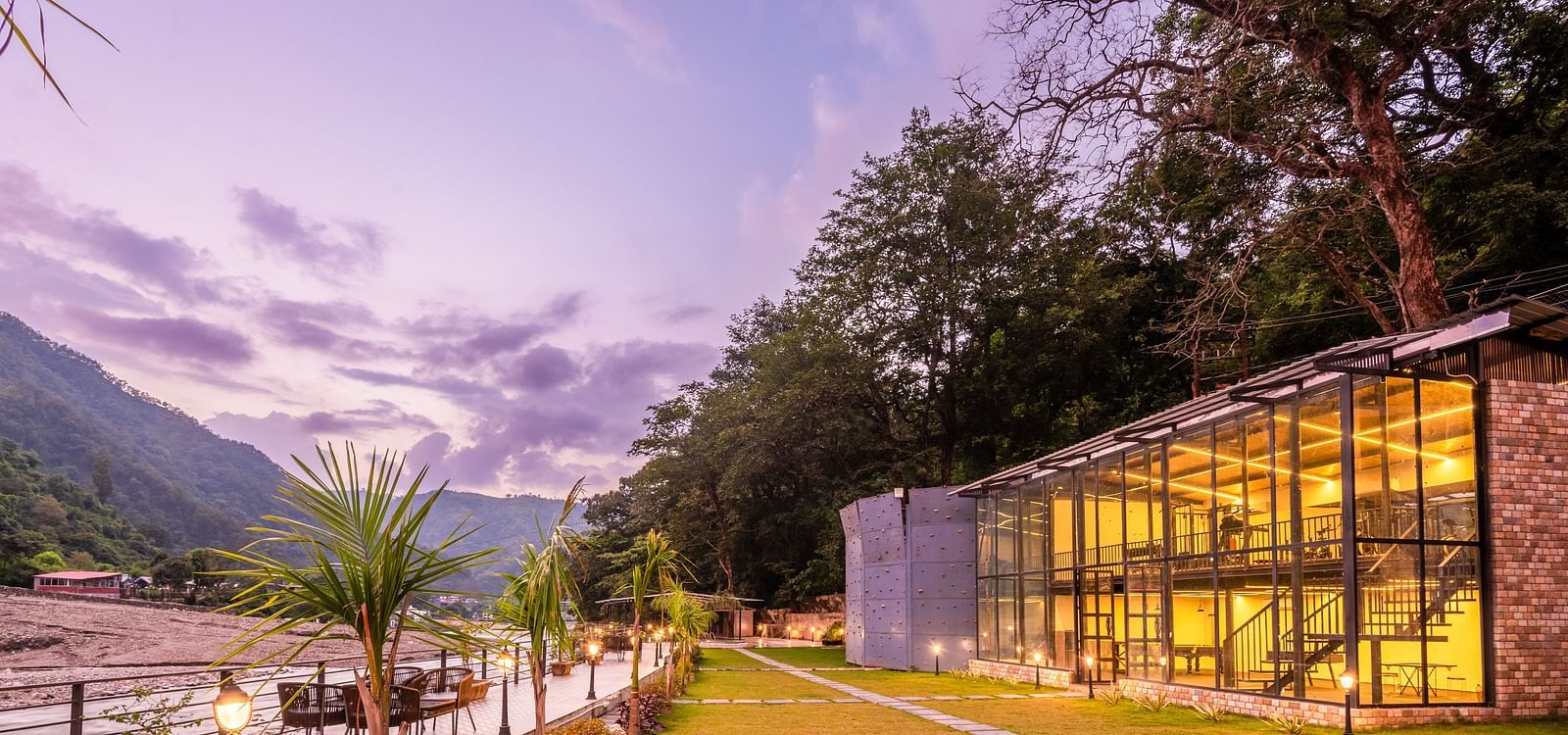 Exterior facade view of DLS Divine River Resort and Spa with stunning lighting and garden area taken in the evening 